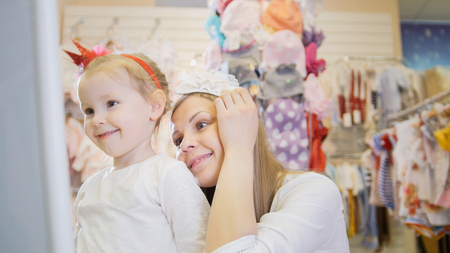 Mother and daughter trying on headbandsの写真素材