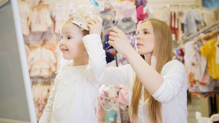 Cute girl tries on a beige bowの写真素材