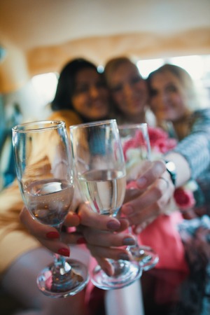 Blurred girl party - happy women celebrating in limousine, drink champagneの写真素材