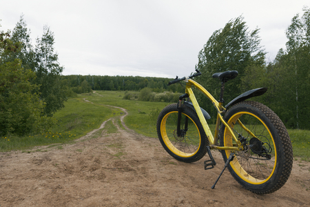 Fat bike - rear view of dirty bicycle at summer countryside, horizontalの写真素材
