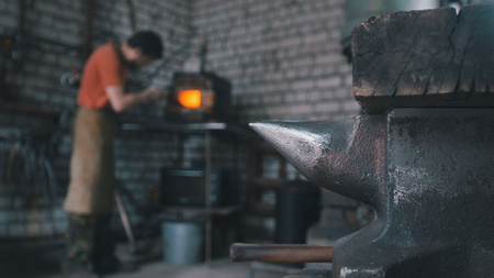 The blacksmith in forge near furnaceの写真素材