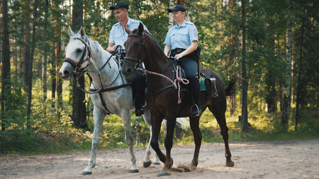 Kazan, Russia - 28 july 2017: Police - man and woman - on horses in forestのeditorial素材