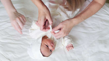 Mother is swaddling her child - newborn baby infantの写真素材