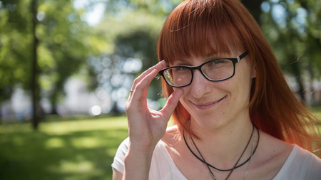 Redhead girl in glasses in the parkの写真素材