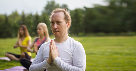 Yoga sportsmen in park - performs exercise outdoors outdoor at morningの写真素材