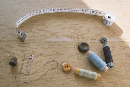 Sewing still life - multicolored cotton thread spools, thimble, needle, measuring tapeの写真素材