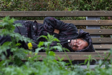 KAZAN, RUSSIA - 9 SEPTEMBER 2017: homeless alcoholic beggar man is sleeping on bench in parkのeditorial素材