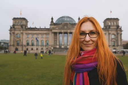 Red hair young woman near the Reichstag building german government in Berlin, Germanyの写真素材