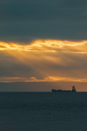 Container Cargo ship in the ocean at sunset sky, silhouetteの写真素材