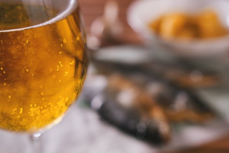 Beer and dry fish on wooden table - blurred backgroundの写真素材
