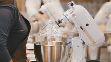 Woman on the kitchen near electric mixer ready for cookingの写真素材