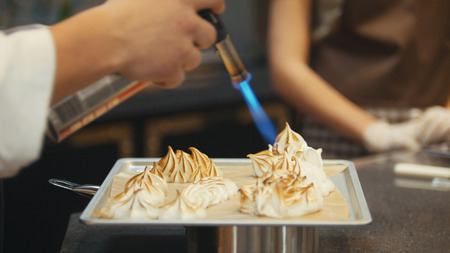 Process cooking of meringue - chef use fire for decorates dessertの写真素材