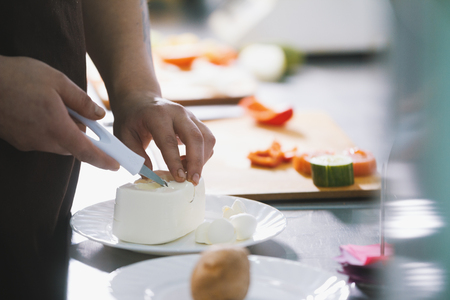 Chef cut the cheese feta for salad in commercial kitchenの写真素材