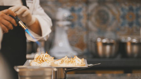 Cooking of meringue - chef use fire for decorates dessertの写真素材