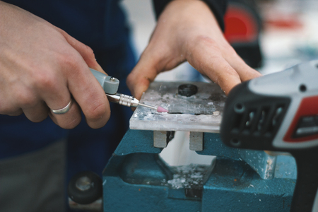 Man is polishing detail on vise, close upの写真素材