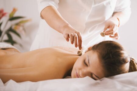 Young beautiful woman in spa receiving procedure of tibetan medicineの写真素材