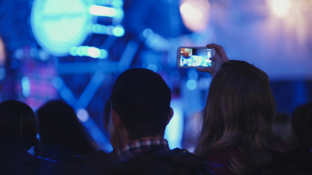 Spectators at concert - people shooting performance on smartphone, scottish musicians