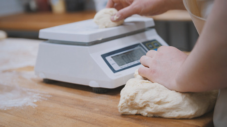Baker weighing dough for bakingの写真素材
