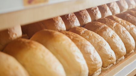 Many loaves of bread on a tray for sale