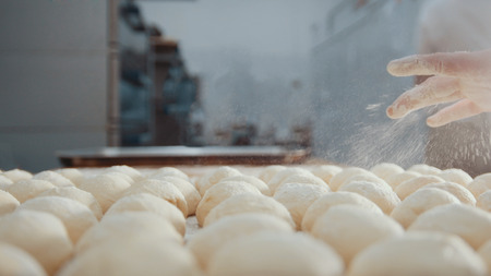 Cook sifts flour and sugar decorating pies in the bakery close up.の写真素材