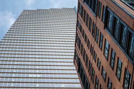 Bottom view of modern skyscraper and brick building