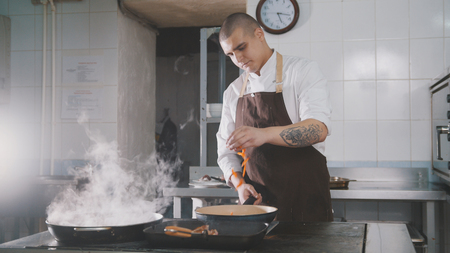 Chef cooking spaghetti in restaurantの写真素材