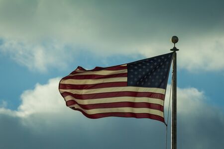 Waving usa flag in front of cloudy sky