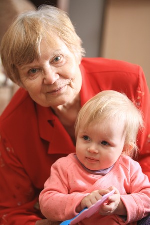 Little sweet girl is playing with grandmother at home