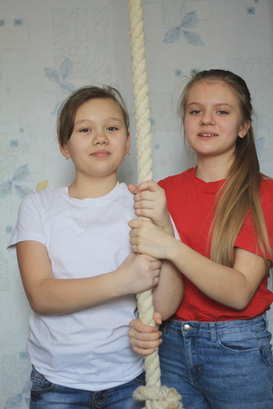 Portrait of two girlfriends or sistersat home posing near gymnastic ropeの写真素材