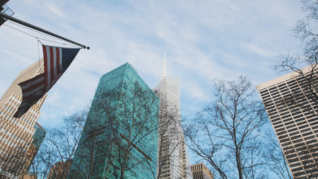 Skyscrapers in fog, view from bottom, american flag on the building