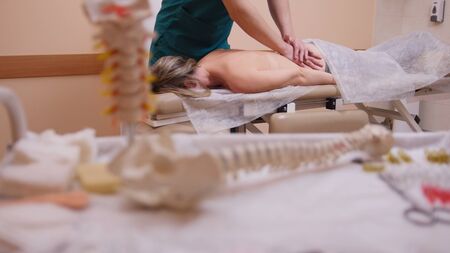 Chiropractor massaging a woman lying on a massage tableの写真素材