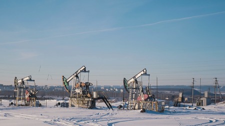 Working oil pumps in the winter fieldの写真素材