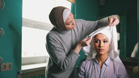 Two muslim women to tie Islamic turban, preparing for a weddingの写真素材