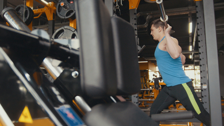 Young athlete does physical exercise in the gym