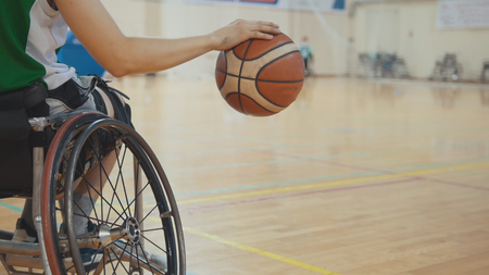 Wheelchair basketball player dribbling the ball quickly during training of disabled sportsmenの写真素材