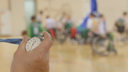 Stopwatch in hand of coach during training for wheelchair basketballの写真素材