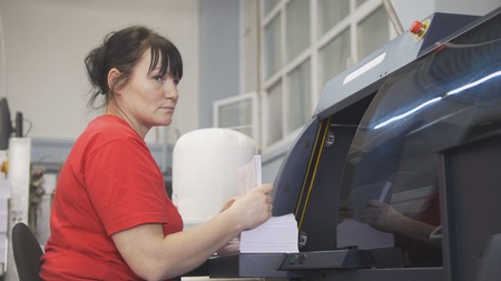 Female worker working with the printing press