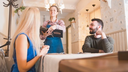 Happy caucasian couple takes the menu at the cafeの写真素材