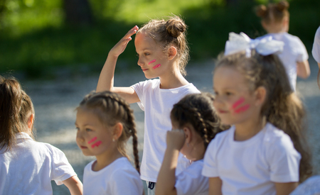 Caucasian little girls team with painted faces playing in summer parkの写真素材