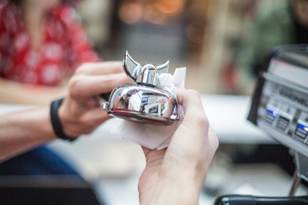Barista wipes a metal bell for orders with a napkinの写真素材