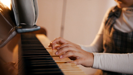 A baby playing piano on music lesson. Music notes on the music standの写真素材
