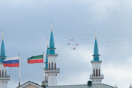 Kazan, Russian Federation - Oktober 27, 2018: Aerobatics performed by aviation group of Military-air forces of Russia "Strizhi". Kul Sharif mosque and flags of Russia and Tatarstan on the foreground.のeditorial素材