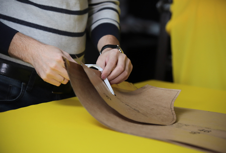 A man prepares templates for sewing. Close up