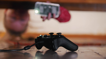 Joystick under the bed. Girl looking under the bed