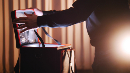 A man opening case with light in it and looking insideの写真素材