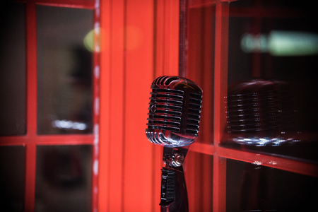 A old style retro microphone on red background
