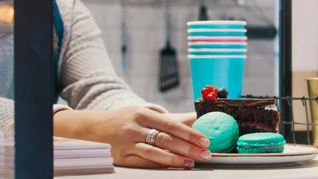 Serving a plate with blue macaroons on the checkoutの写真素材