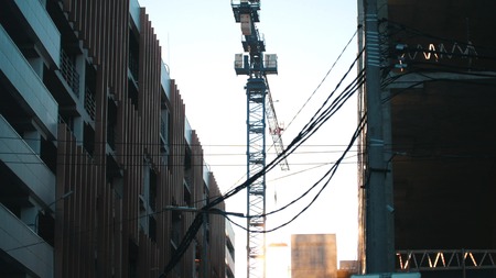 Working tower crane. Hanging wires on the foreground. Industrial.の写真素材
