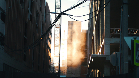 Construction site. Working tower crane. Hanging wires on the foreground. Sunsetの写真素材