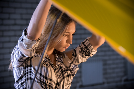 Car repair service. Young sexy woman stands in front of an opened car hoodの写真素材